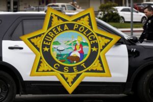 black and white police suv partially visible in photo with a eureka police cset badge imposed over the image covering the door in the photo