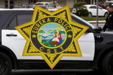 black and white police suv partially visible in photo with a eureka police cset badge imposed over the image covering the door in the photo
