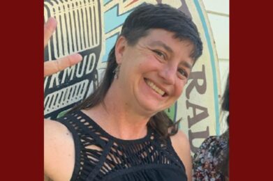 a smiling woman with dark hair in front of the kmud logo